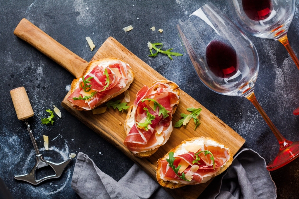 planche de tartines au jambon et verres de vin